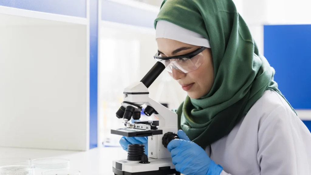 عالمة محجبة تستخدم المجهر في مختبر في خبر رد كيري كينيدي على تصريحات أخيها