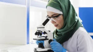 عالمة محجبة تستخدم المجهر في مختبر في خبر رد كيري كينيدي على تصريحات أخيها