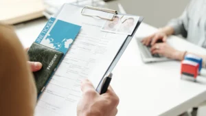 متقدم يحمل جواز سفر وأوراق طلب في خبر تجميد تأشيرات الهجرة
