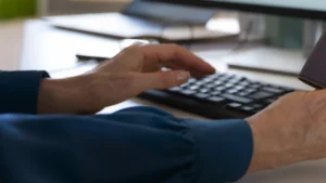 شخص يتابع ملفه على الحاسوب في خبر الحماية المؤقتة للسودانيين